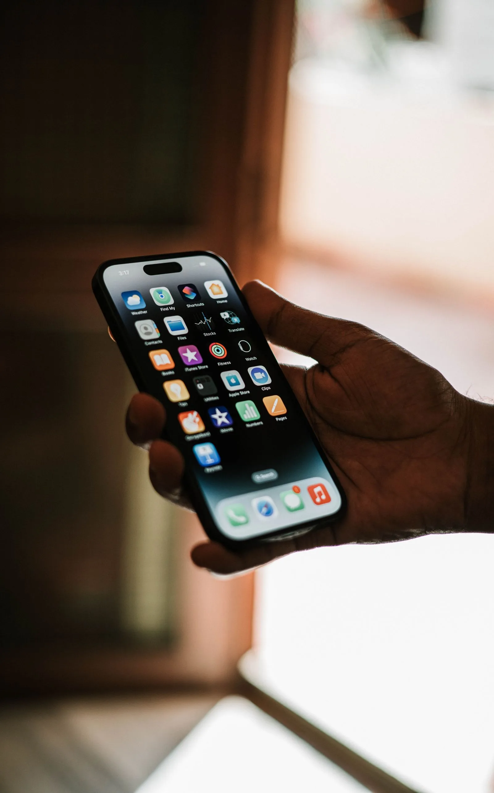 Hand hält Smartphone im Gegenlicht